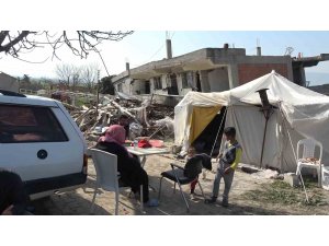 Depremde canlarını son anda kurtaran aile, yıkılan evlerinin önünde kurdukları çadırda yaşıyor